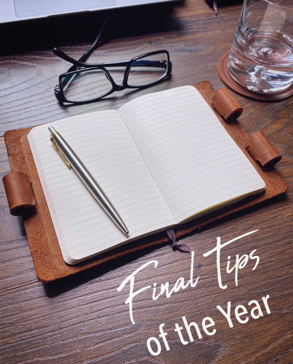 Final Tips of the Year 2020 - Pictured: Mini Cut Refillable Leather Journal on desk with glasses and a leather coaster and stainless steel parker jotter pen.